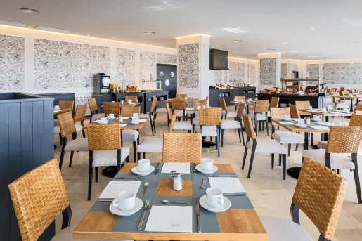 Indoor dining hall with wooden tables and woven chairs