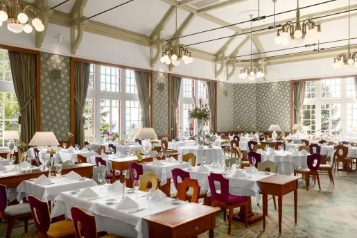 hotel restaurant with green curtains and chandeliers