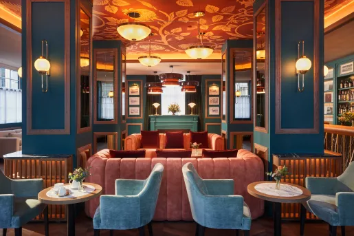 Blue lounge room with red and blue cushioned chairs and large light fixtures