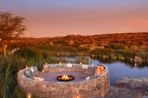 A circular seating area with a fire pit in the center, overlooking mountains and canyons