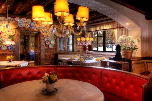 large red booth around a table under a chandelier