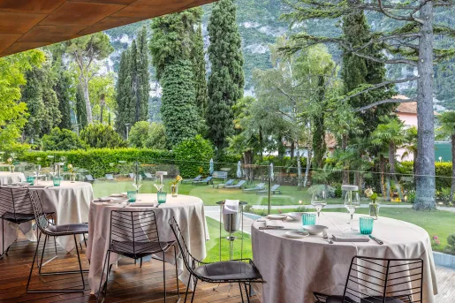 Multiple dining tables on the balcony overlooking a large grass area