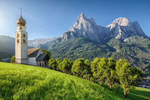 Rustic church next to a tall mountain in the background