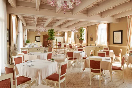 Indoor dining room with white tables and red chairs