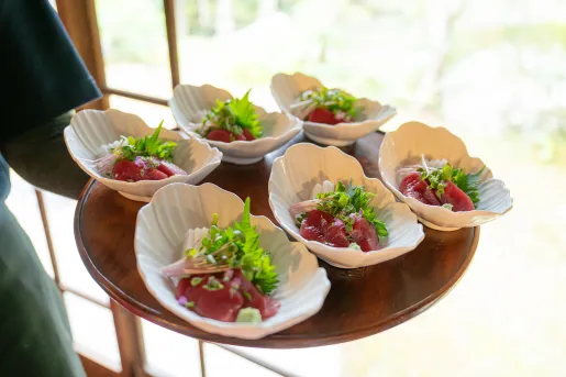 Six plates of raw fish with greens