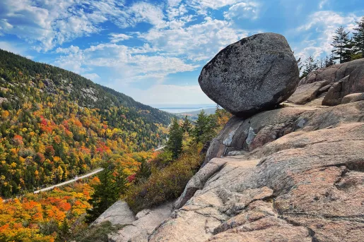 Boulder on a rocky edge overlooking trees