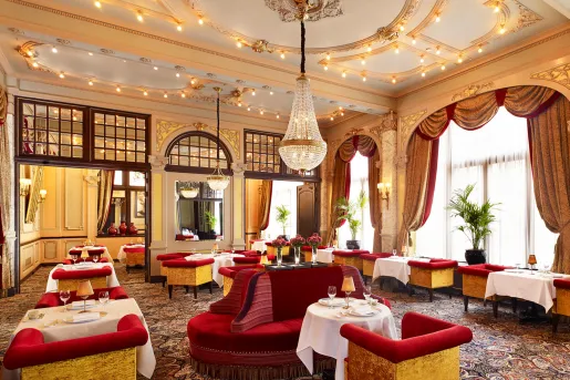 Dining room with red couches and white curtains