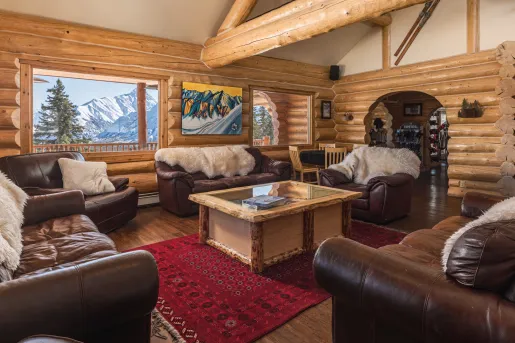 Leather chairs in a cabin with fur blankets on each sofa