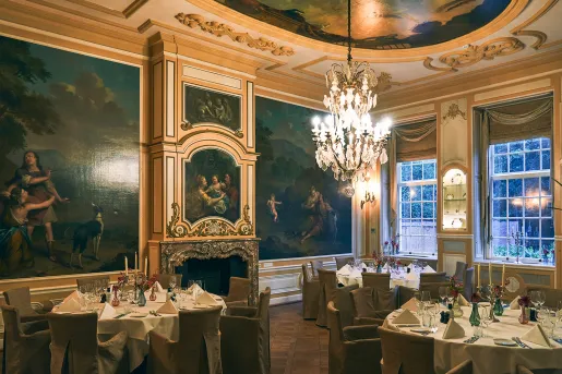 Dining hall with large circular tables and paintings on the wall