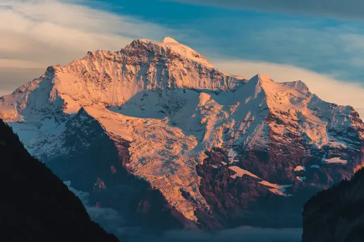 Large, snow-capped mountain with the sunset hitting on it