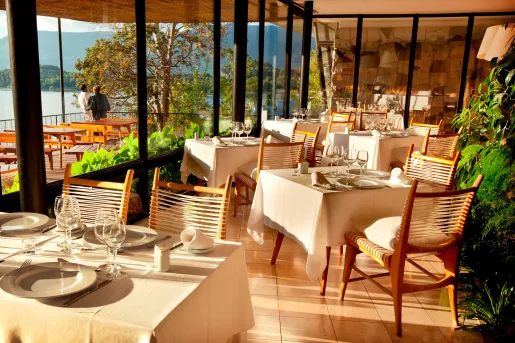 Dining area with large windows and the sunshine hitting each dining table