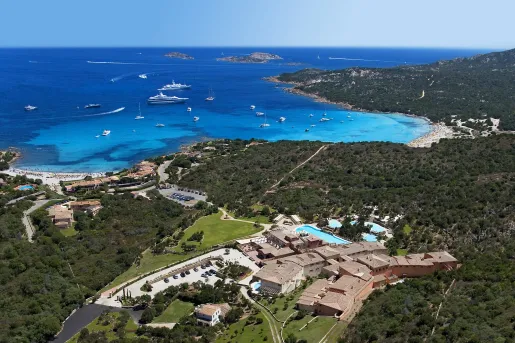 Hotel building surrounded by trees and the ocean