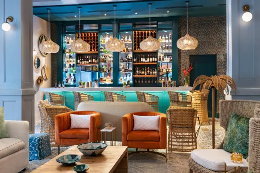 Indoor lounge with a bar in the background and cushioned chairs