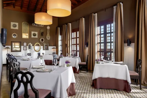 Dining area room with white dining tables and wine glasses on each table