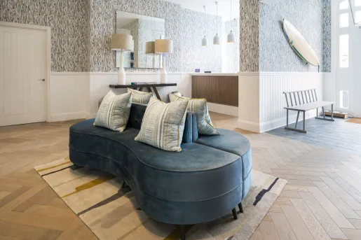 Lobby with a blue sofa and white pillows in the center