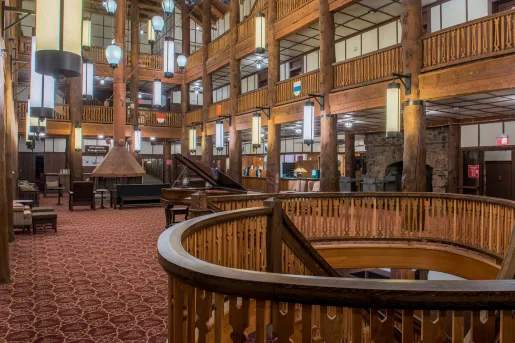 Indoor hotel lobby with large, wood pillars along 3 stories