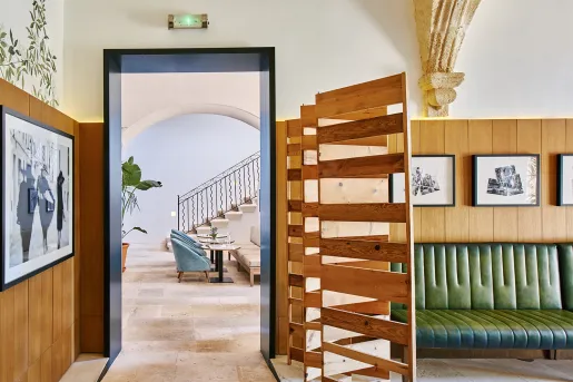 Hallway leading to another room with cushioned chairs and a staircase