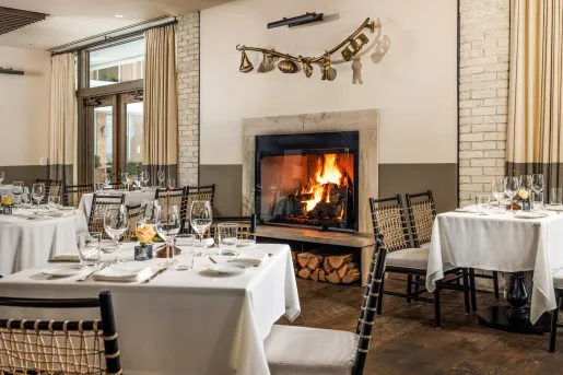 Restaurant dining hall with white dining tables and a fireplace