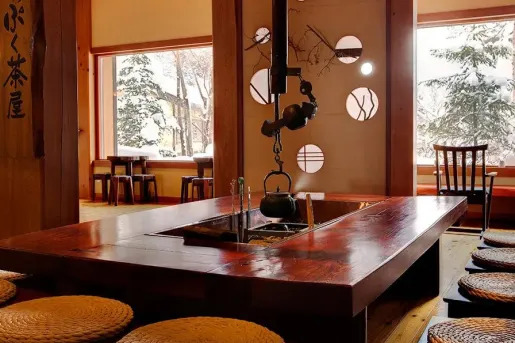 Rectangle dining table with a kettle handing from a metal pipe in the ceiling