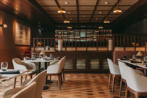 Restaurant dining room with cushioned chairs and marble tables