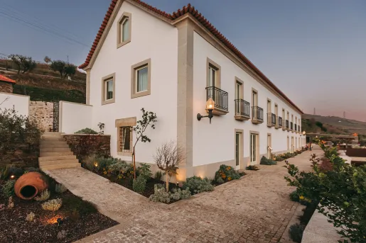 Exterior view of a beige building with stone accents, and a stone pathway in front