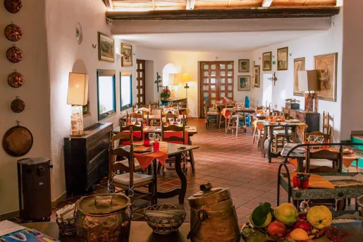 Indoor restaurant with wooden dining tables with paintings on the walls
