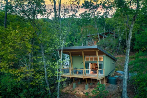 Exterior view of green cabin in the middle of a forest