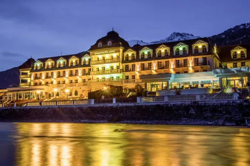 Exterior view of illuminated hotel building with a large lake in front