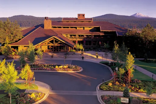 Exterior view of hotel building with a roundabout road and garden in front