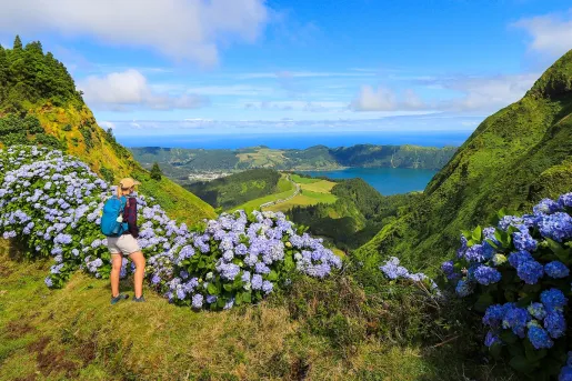 Woman standing on a hill looking out to a large valley