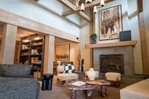 Hotel lobby lounge with cushioned chairs in front of a fireplace