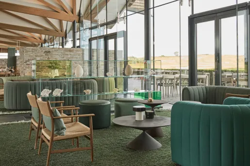 Lounge and seating area with cushioned chairs and large glass walls