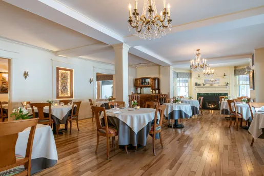 The dining room at The Wentworth Inn in Jackson, New Hampshire, featuring traditional wooden floors and crystal chandeliers