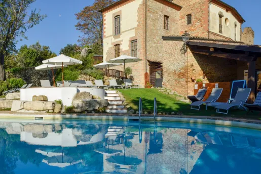 Outdoor pool with a brown, stone building in the background