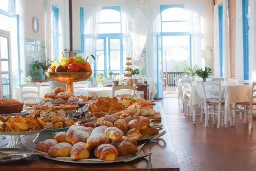 Restaurant with a large table in the center full of pastries and fruit