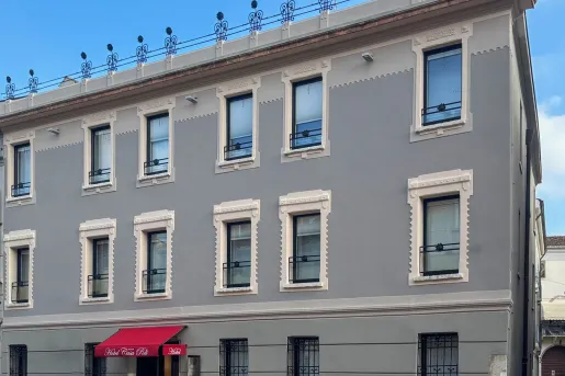 Exterior view of gray hotel building with large windows