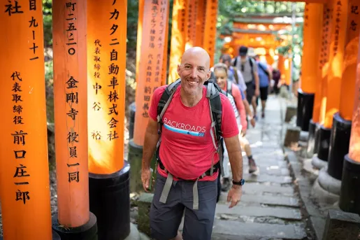 Group of people smiling while walking through large shrine arches