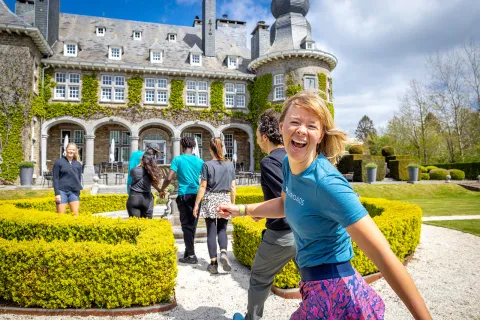 Guests walking towards stone building, one is smiling at camera.