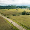 Vast, open California road with s very small bicyclist in foreground.