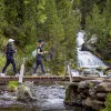 Hiking across a bridge with a waterfall in the background