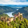 Forested landscape with Aggstein castle ruin and the Danube river at sunset in Wachau, Austria.