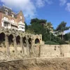 Large house on top of stone castle ruins with a stone pathway on the ground level