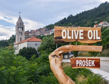 Shot of Croatian hillside town, Prosek, and 'Olive Oil" sign.