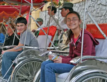 Backroads guests sitting in bike pedal carts in Vietnam