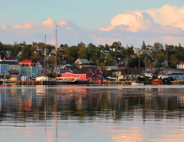 Sunset in Nova Scotia with vibrant red houses scattered throughout.
