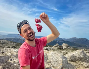 Leader with charcuterie platter, pretending to eat grapes.