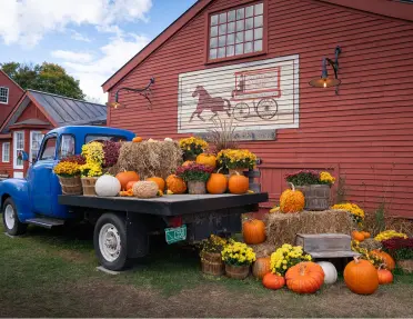Blue truck with stacks of hay and pumpkins